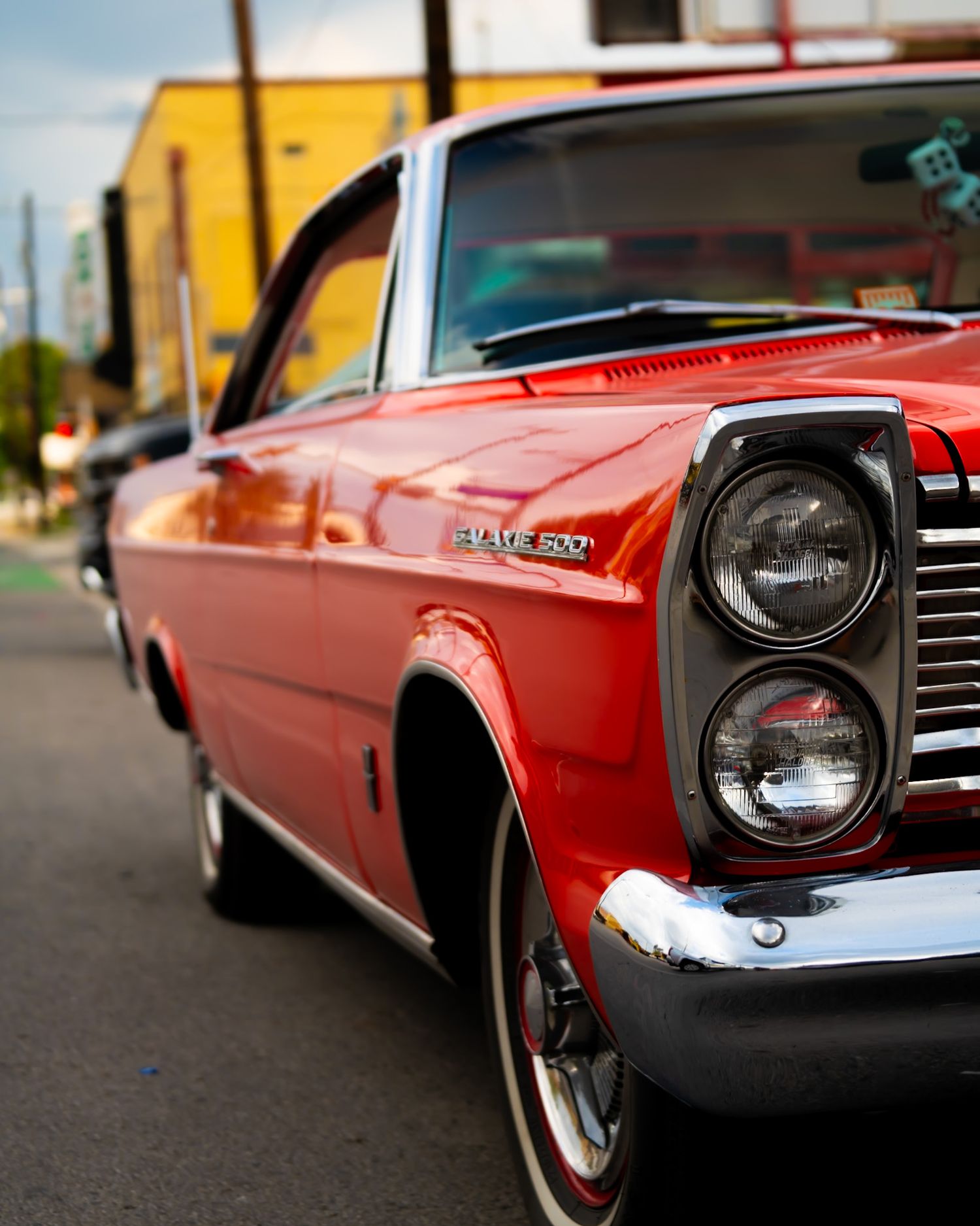 Front view of a vintage red muscle car showing classic headlights and grille. Captured by a Seguin photographer at grain n glass