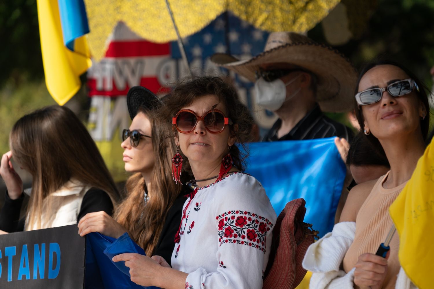Crowd of spectators watching an outdoor event under yellow and blue banners. Captured by a Seguin photographer at grain n glass