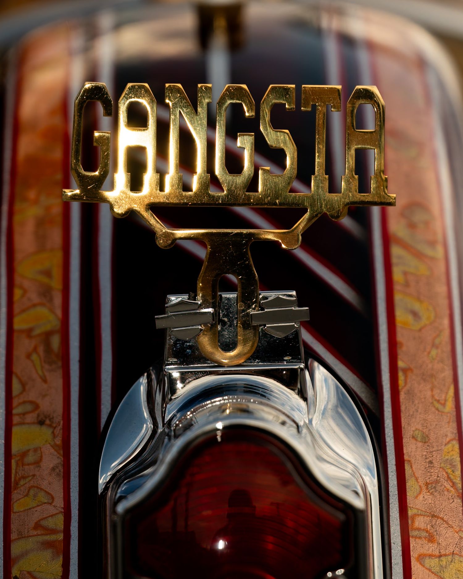 Close-up of motorcycle fender lowrider tag reads gangster. Captured by a Seguin photographer at grain n glass