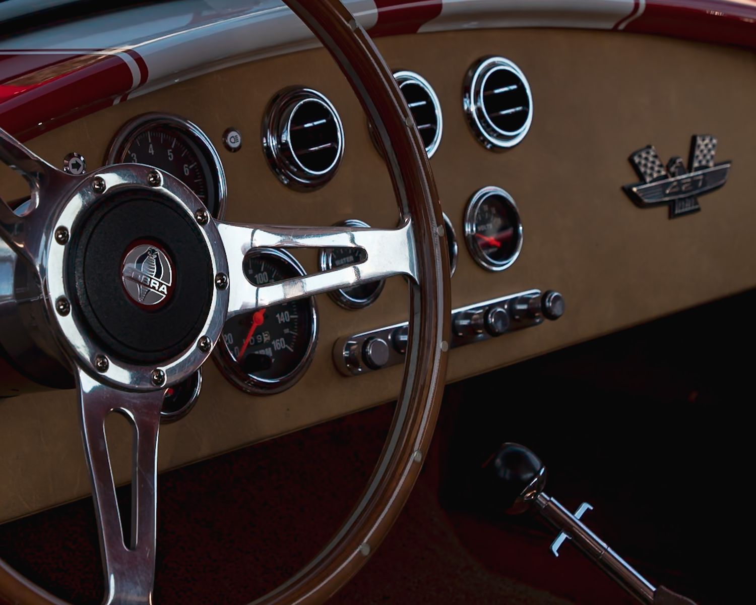 Vintage car dashboard showing classic gauges, steering wheel and controls in warm tones. Captured by a Seguin photographer at grain n glass