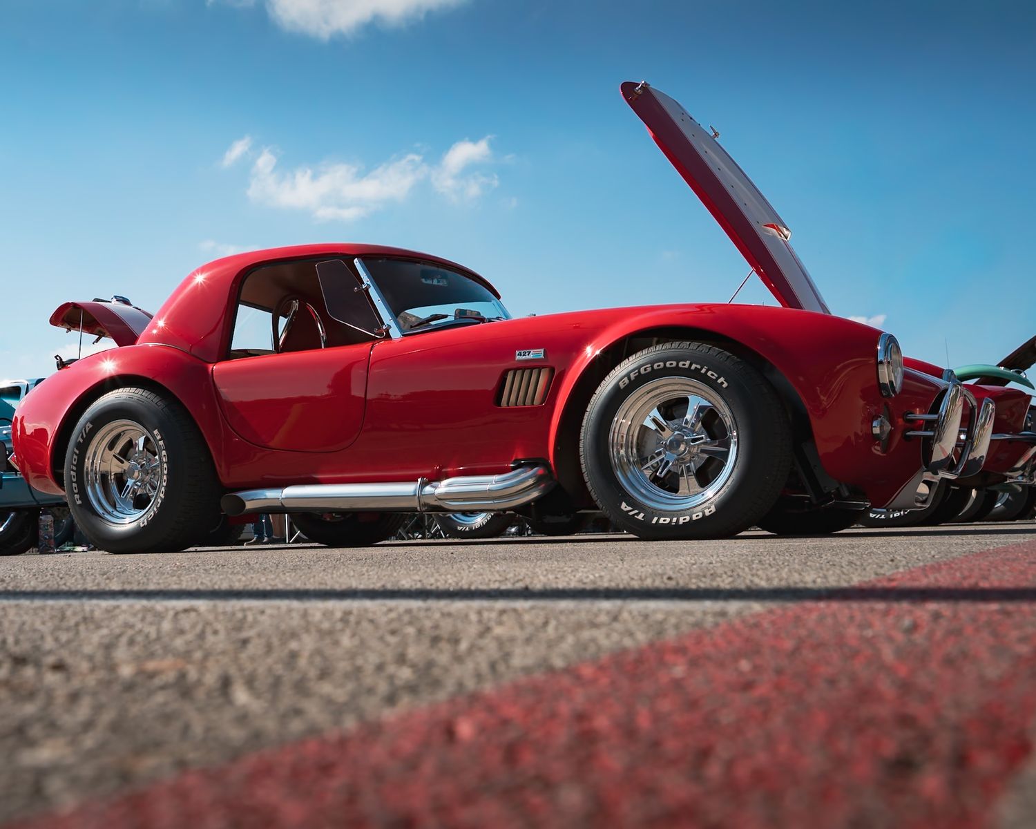 Low angle view of classic 427 cobra lined up on pavement. Captured by a Seguin photographer at grain n glass