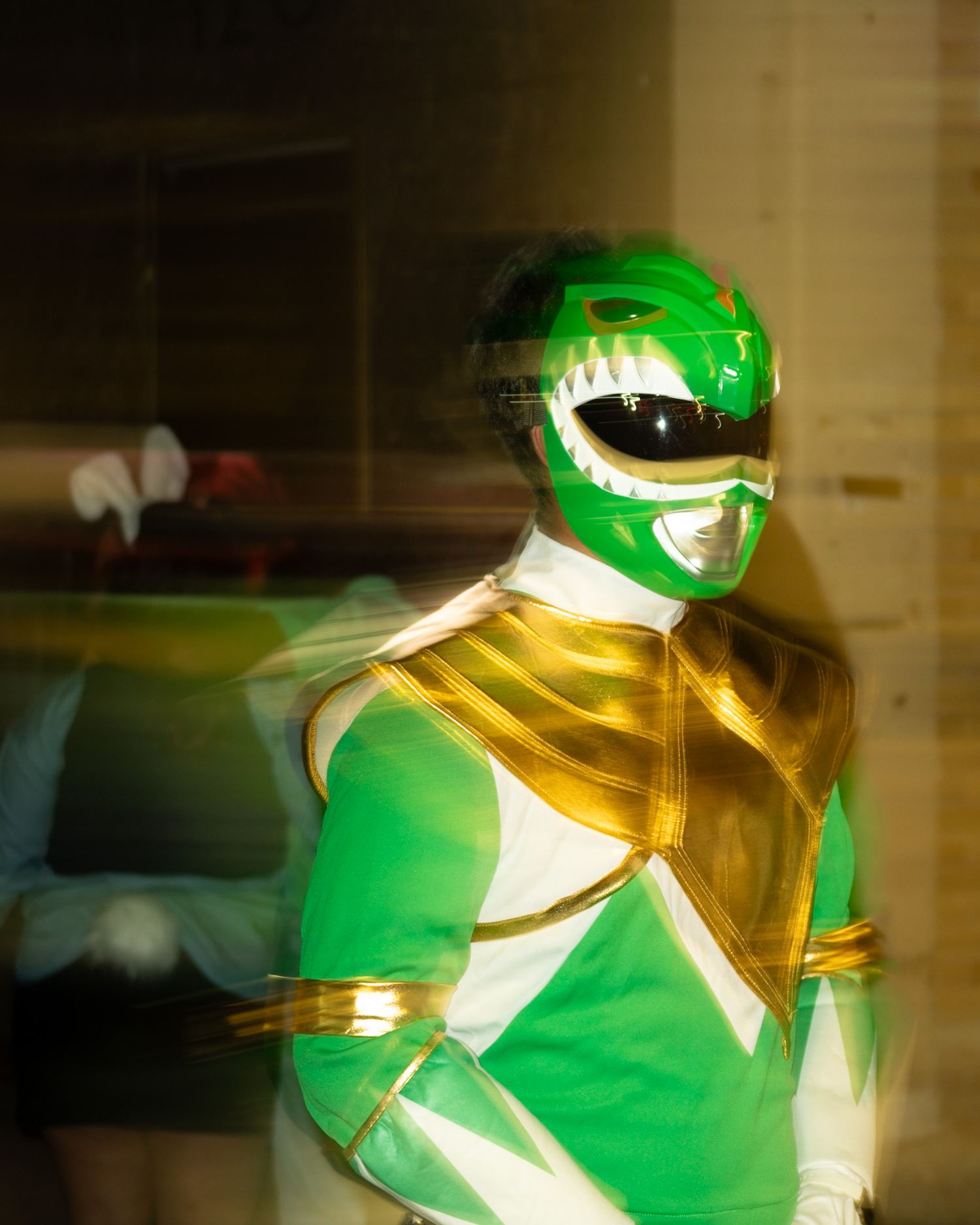 Power ranger green and yellow costume illuminated dramatically against dark background. Captured by a Seguin photographer at grain n glass