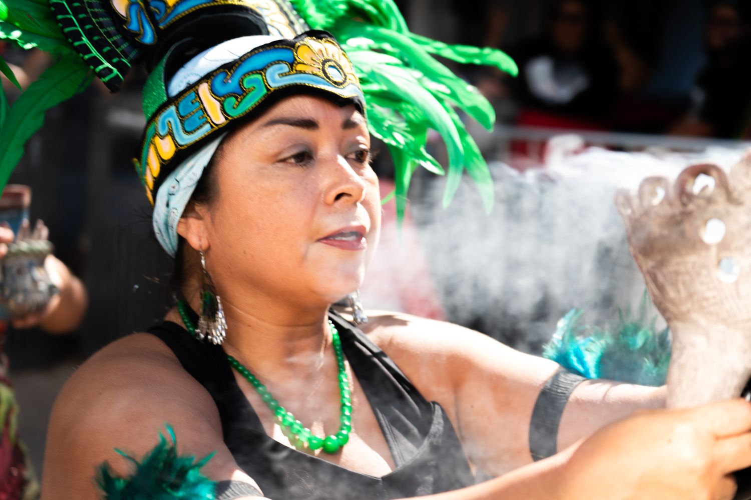 Person wearing green headdress photographed in dramatic lighting.