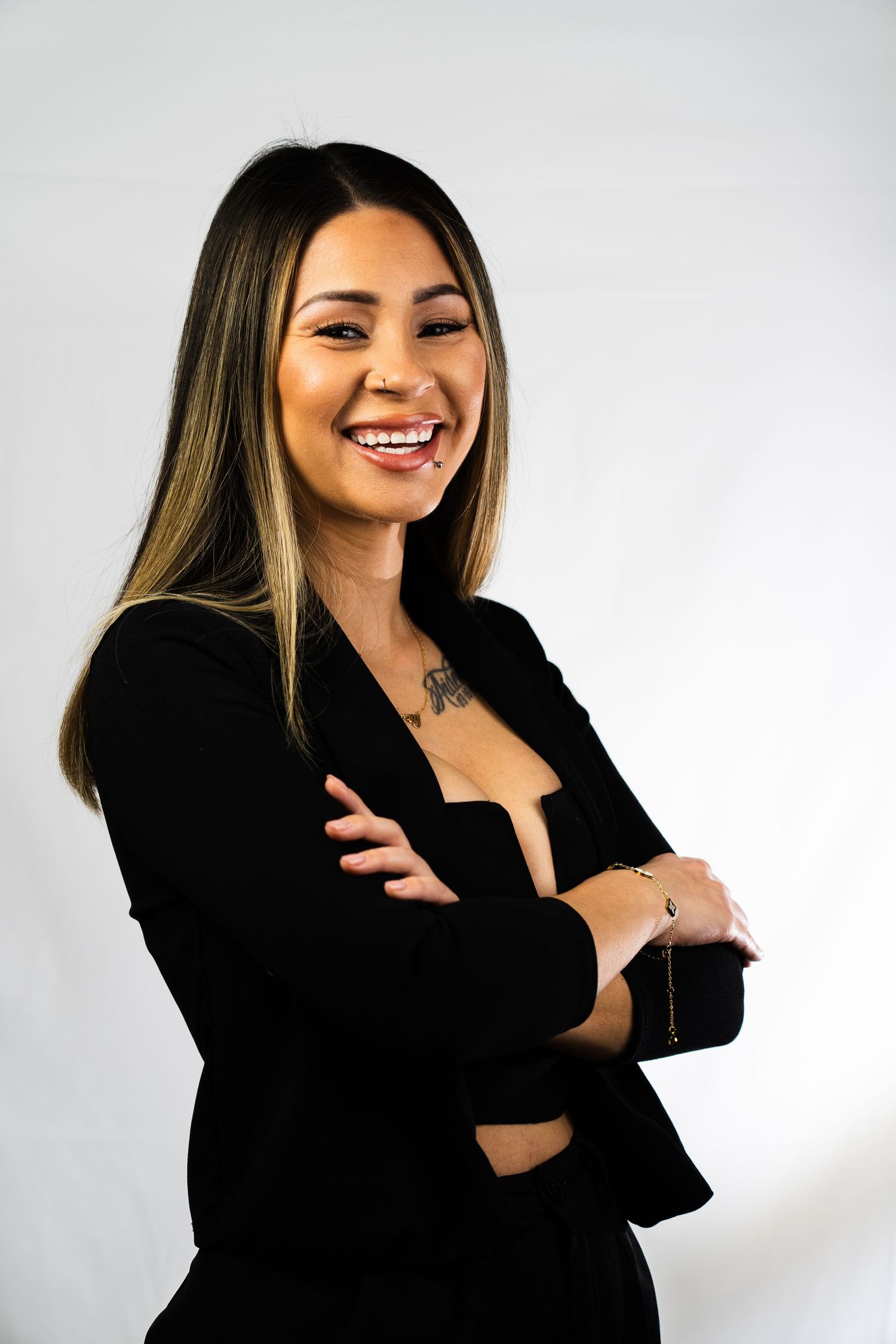 Professional studio portrait showing confident pose in black attire.
