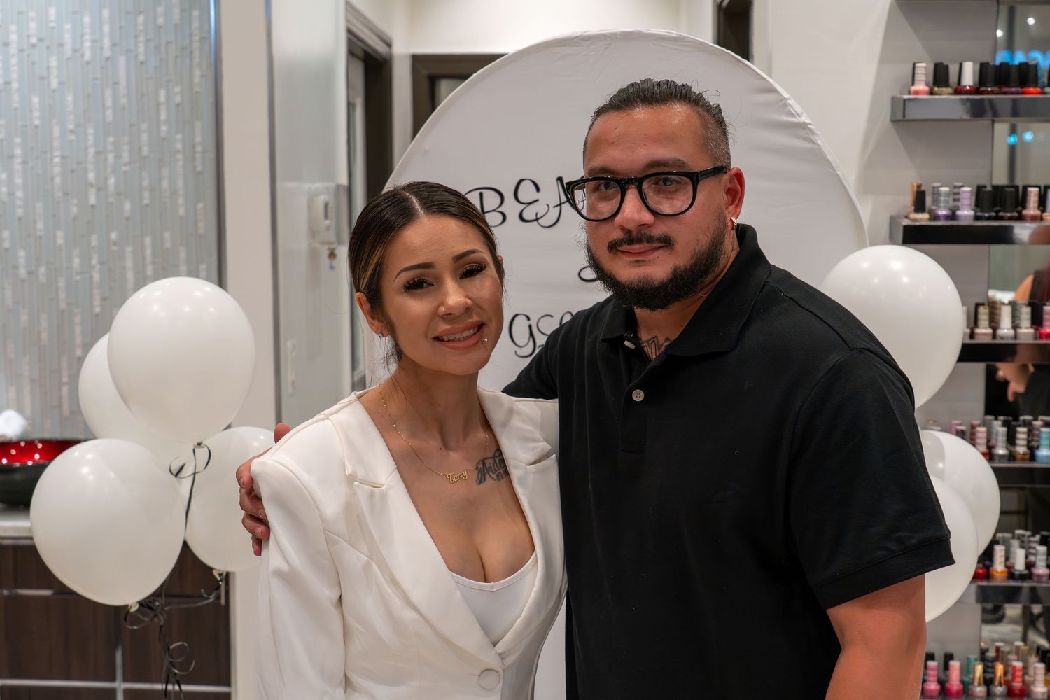 Group photo in a beauty salon with white balloon decorations and shelving displays.