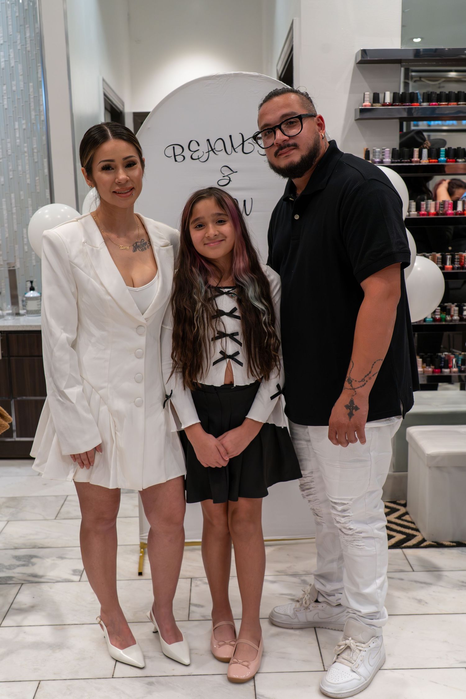 Group photo showing contrasting black and white outfits in a modern salon interior.