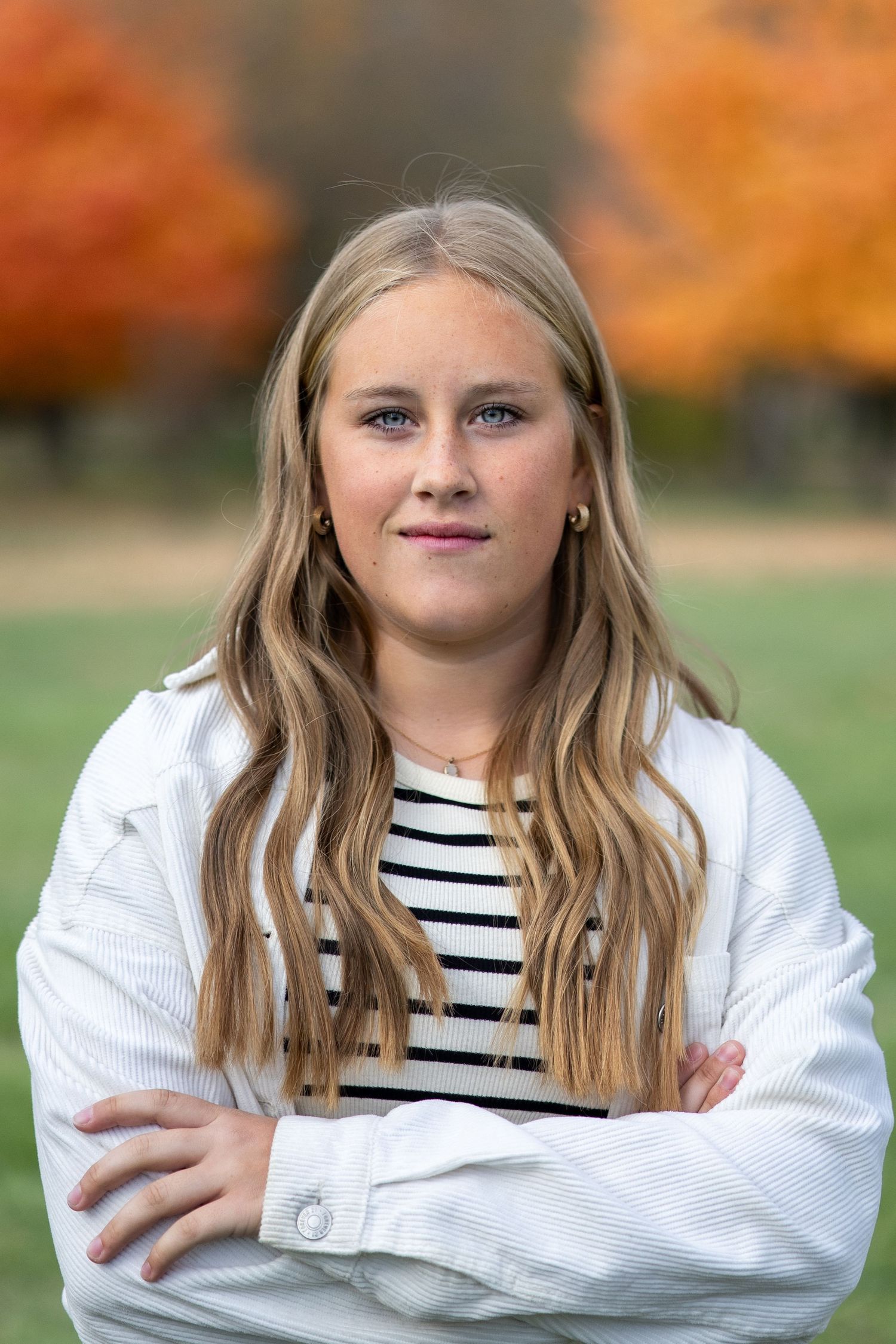 senior girl portrait posed in a field with fall colors