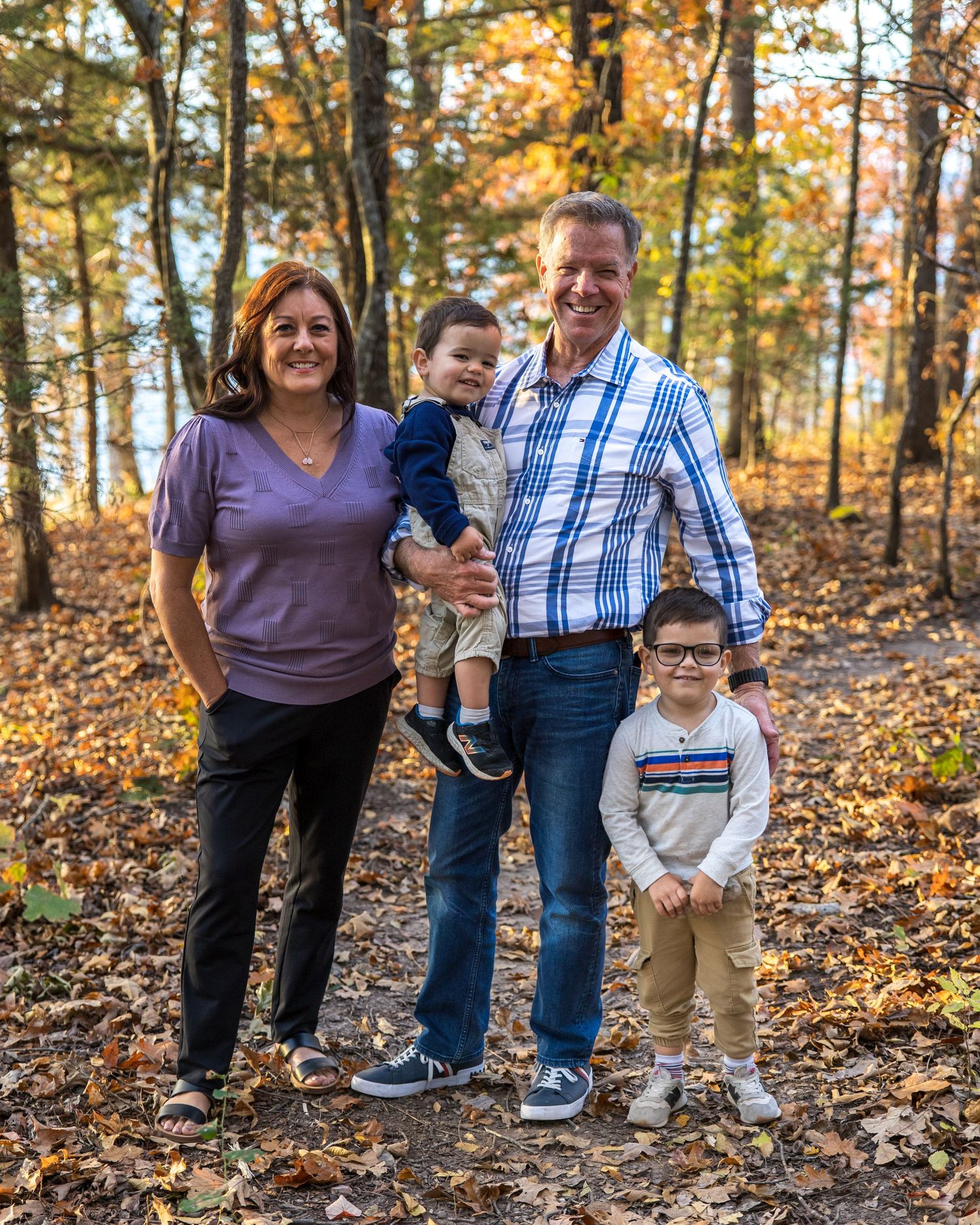 family portrait with grandparents and grandkids in the woods near table rock lake in the ozarks with fall colors