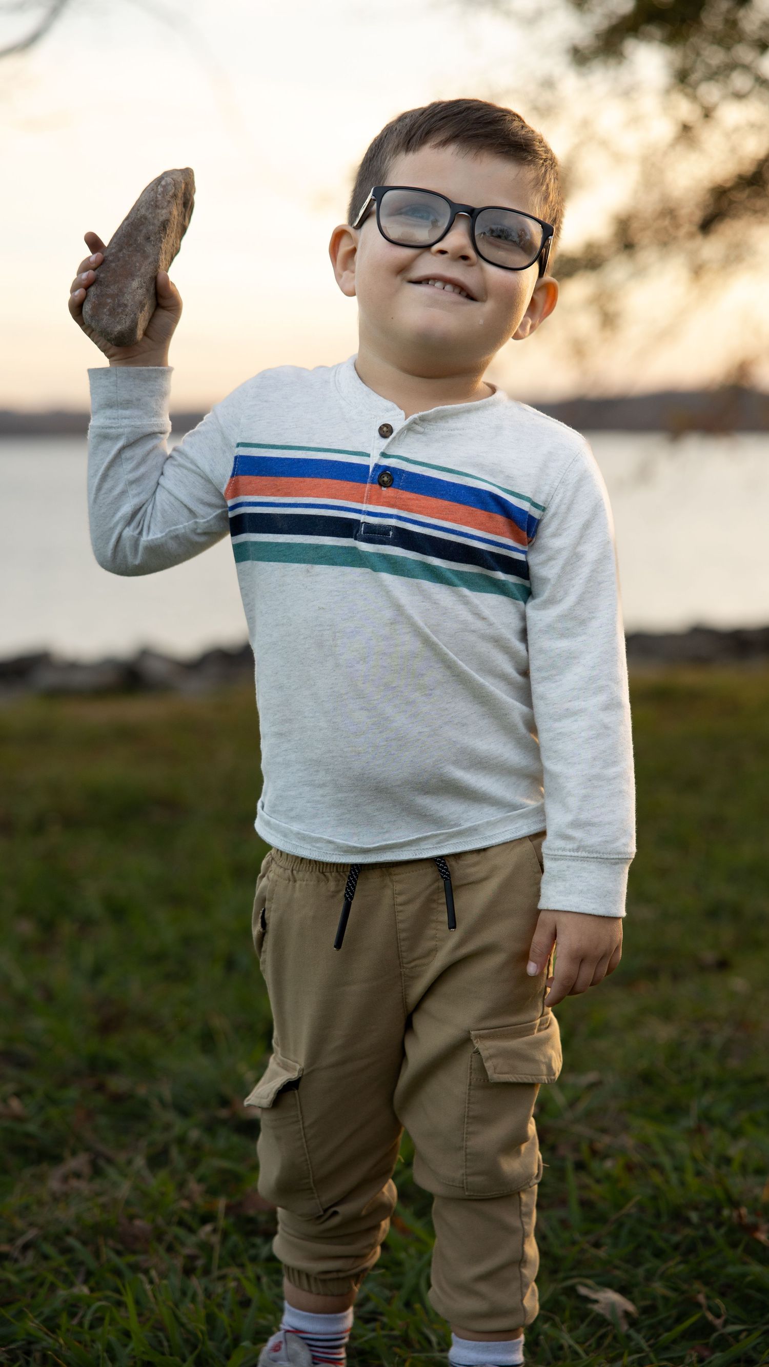 4 year old boy hold his treasure rock and table rock lake in the ozarks