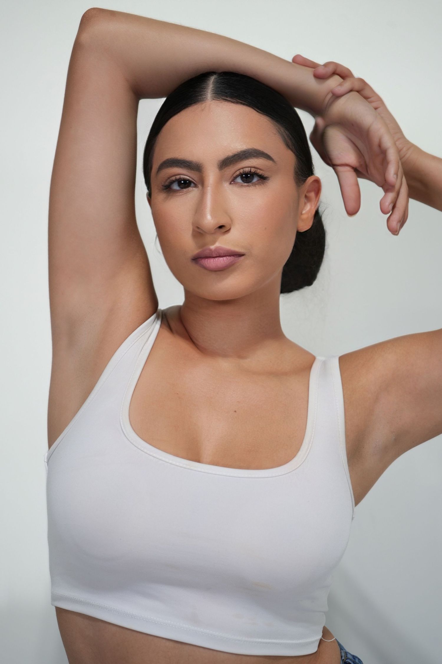 A series of close-up shots showing a person in a white tank top posing against a light background.