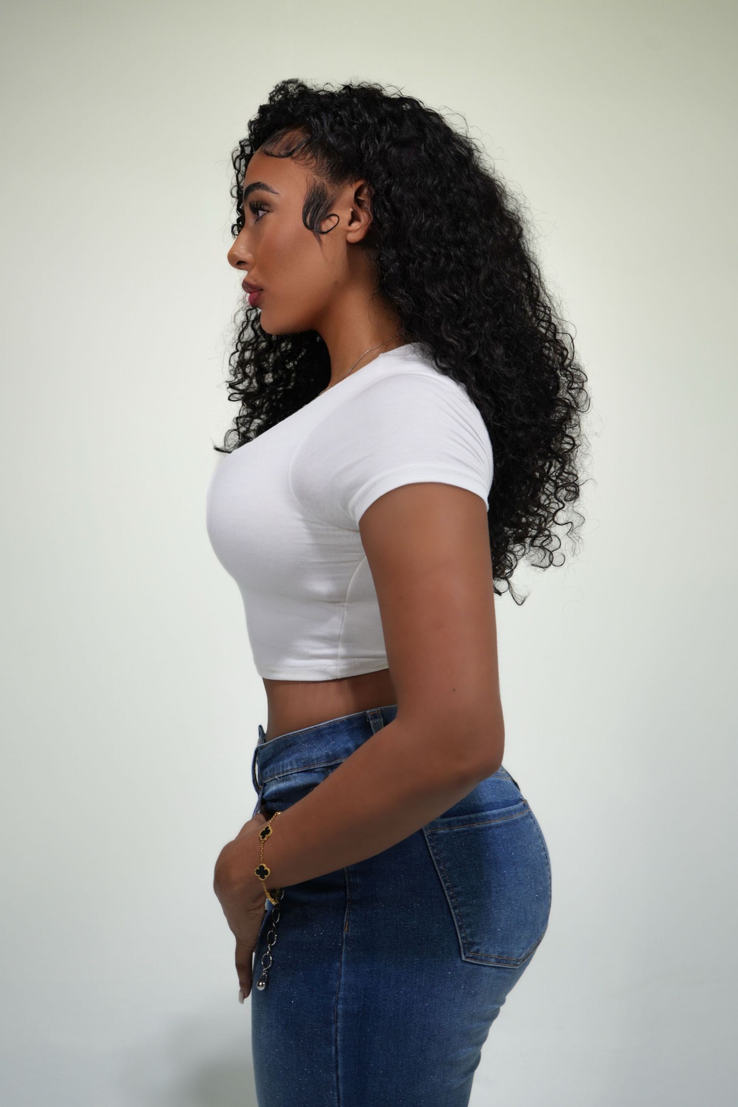 Curvy model showcases casual summer outfit with white tee and dark denim jeans.
