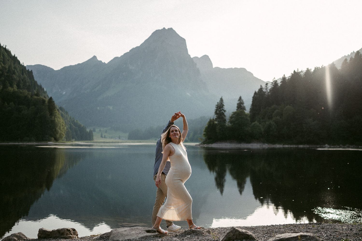 Schwangerschaftsfotografie Zürich Paar bei Sonnenuntergang Tanzen am Bergsee