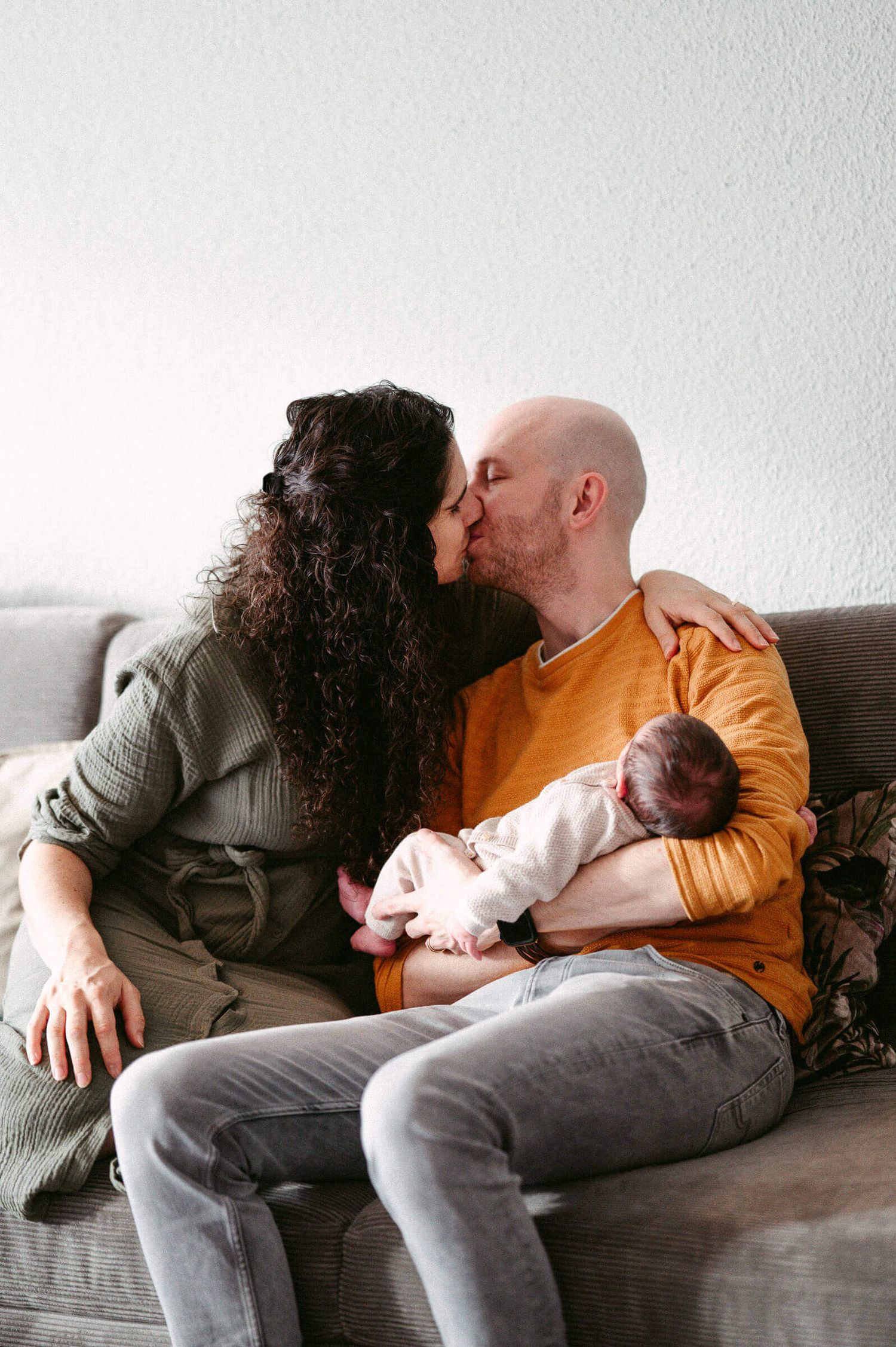 Babyfotografie Zürich Mutter und Vater mit Baby auf Sofa