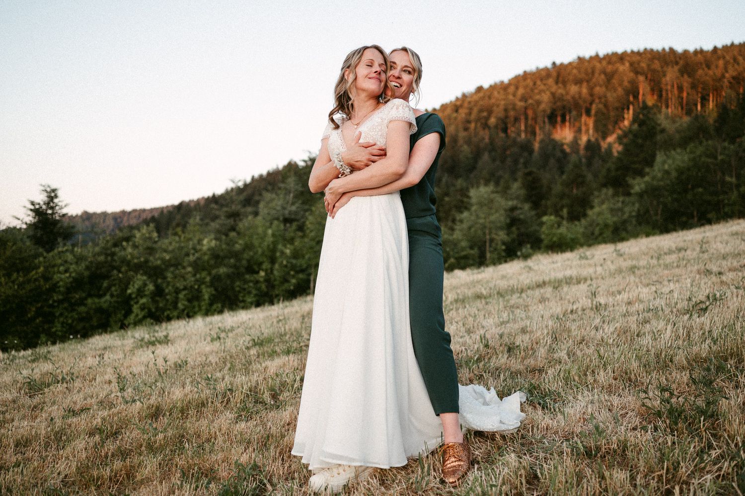 Hochzeitsfotografie Schwarzwald Sonnenuntergang Shooting zwei Bräute auf Wiese Umarmung