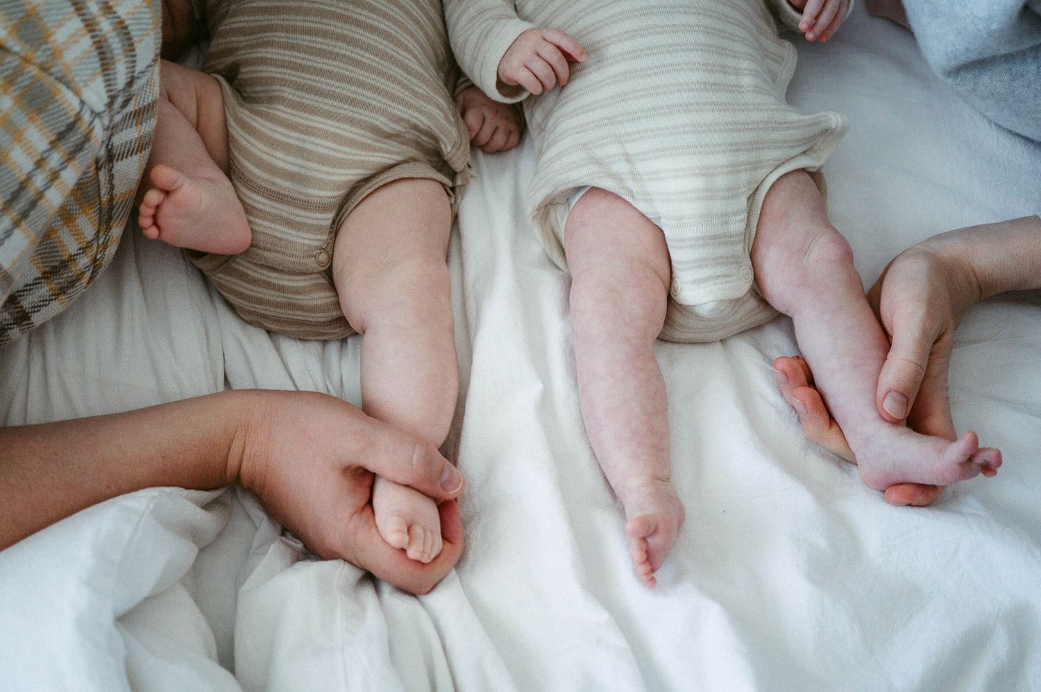 Babyfotografie Zürich Mutter und Vater mit Zwillingen auf Bett