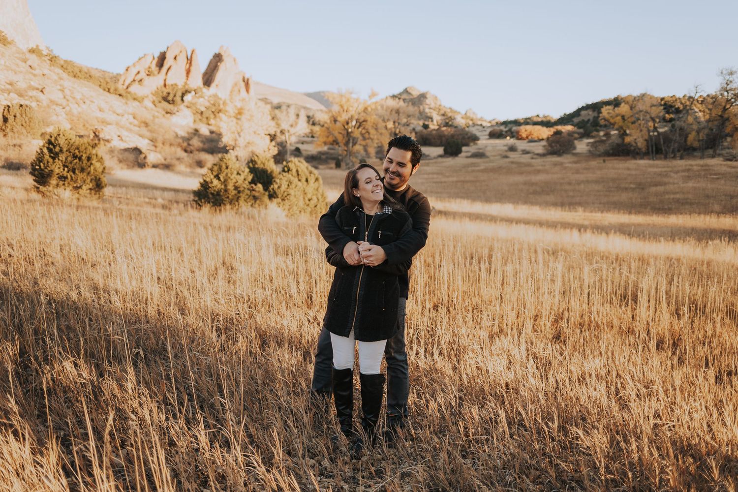 People enjoying golden hour in a wheat field as the sun casts warm light across the landscape.