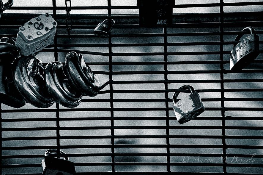 Black and white image of window blinds creating strong horizontal lines and shadows.