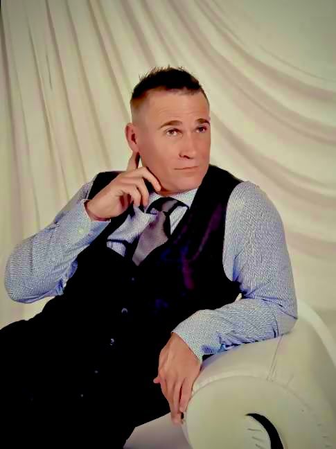 Professional studio portrait against white backdrop in formal business attire.
