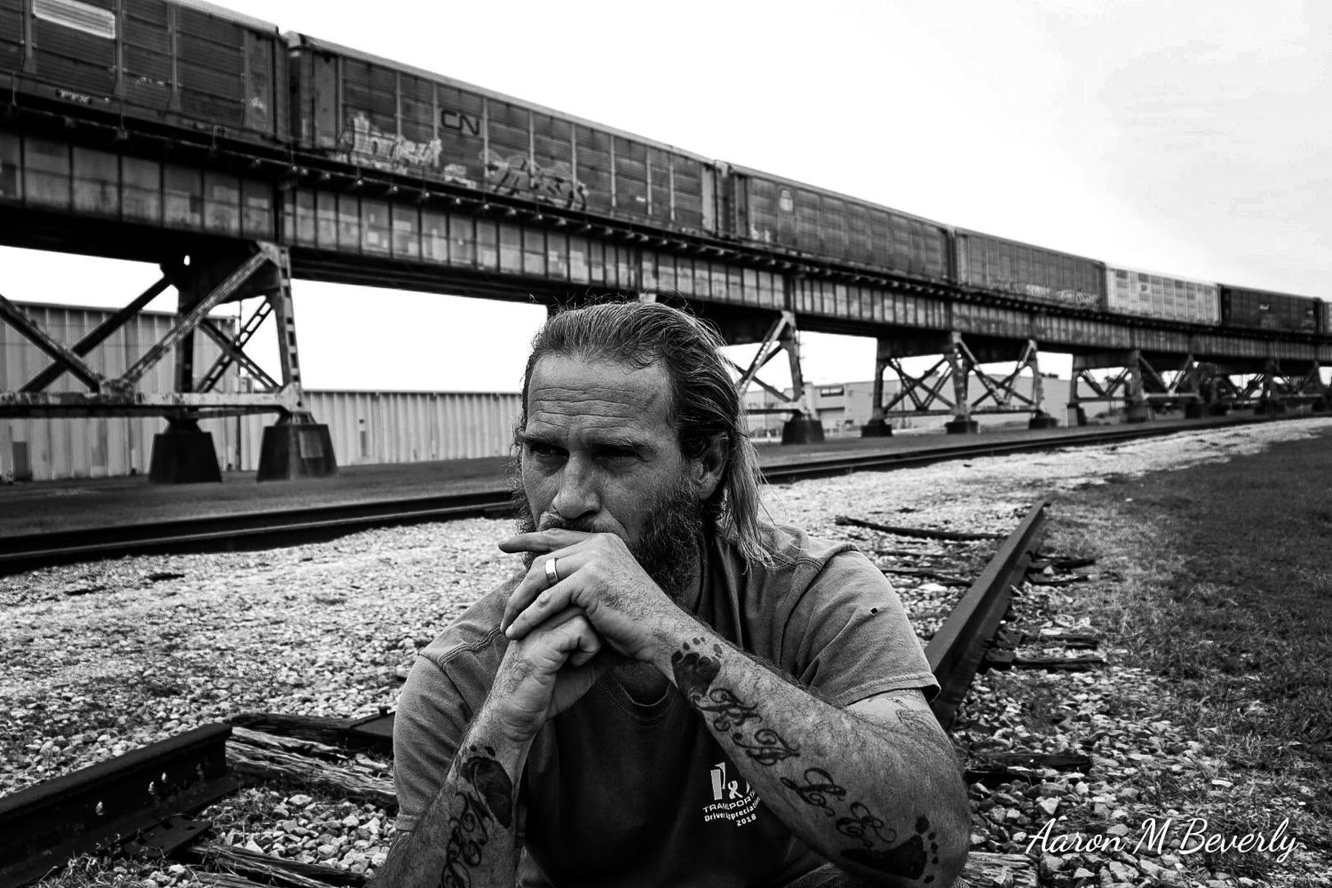 Dramatic black and white series showing figure lying near railroad tracks.