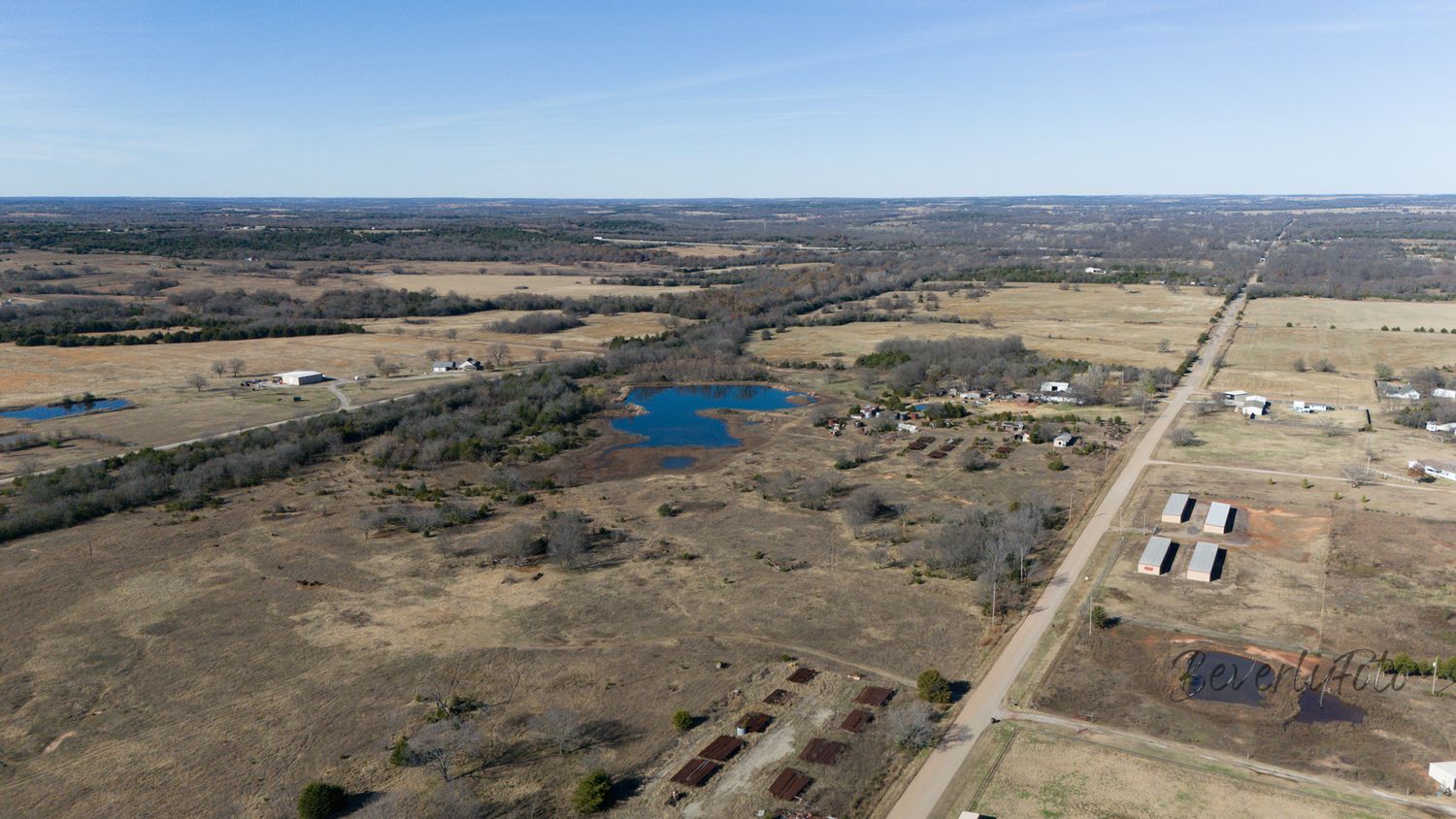 Aerial panoramic view of vast rural farmland and rolling hills stretching to the horizon on a clear day.
