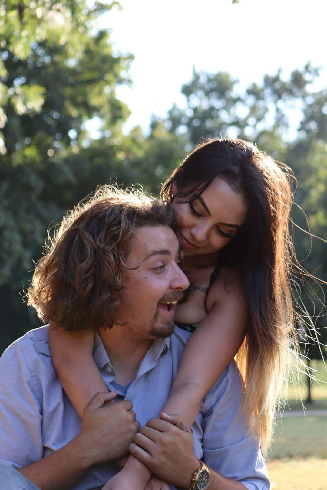 Romantic couple embracing in a sunlit field during golden hour.