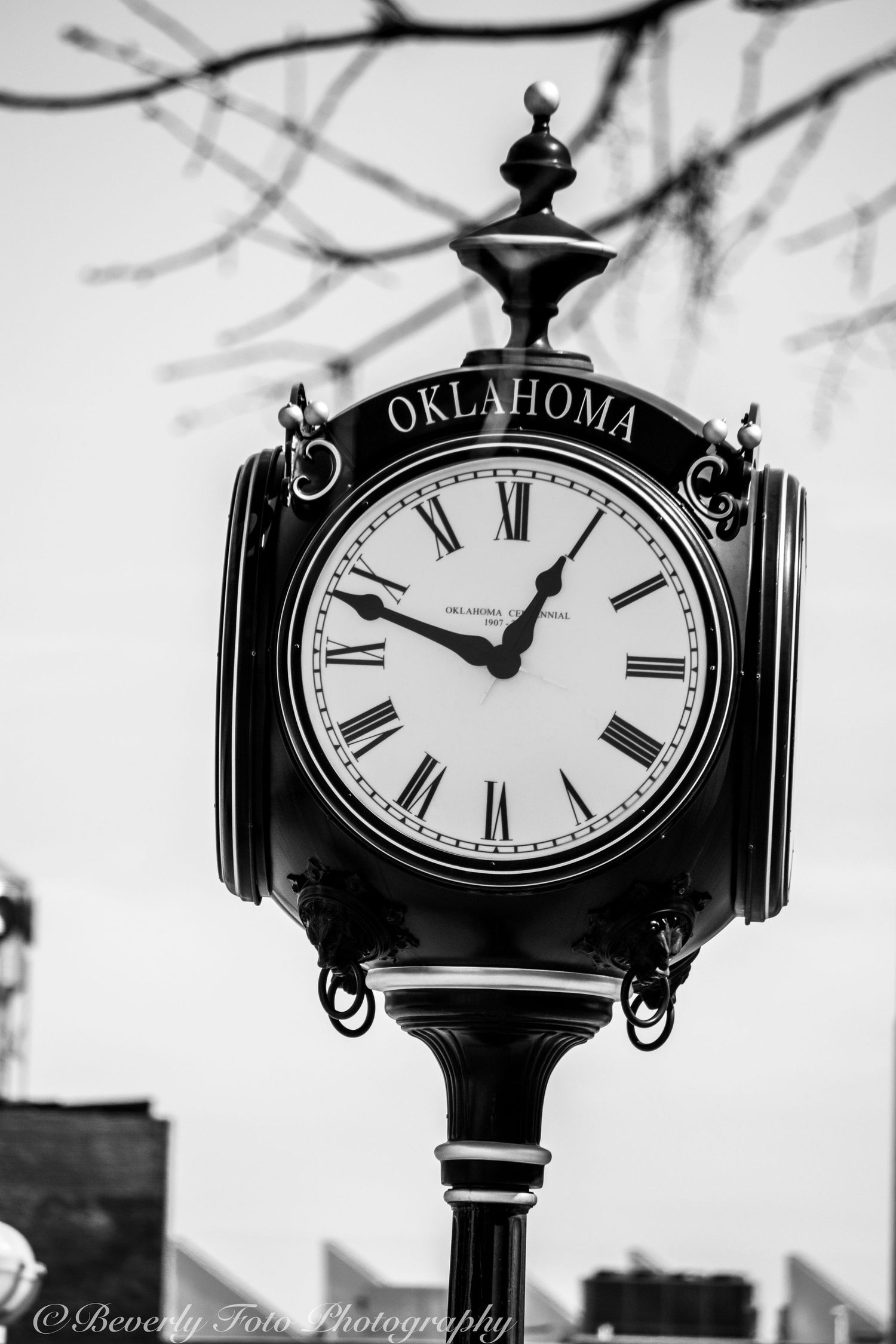 Black and white sequence of an ornate Oklahoma street clock against a cloudy sky.