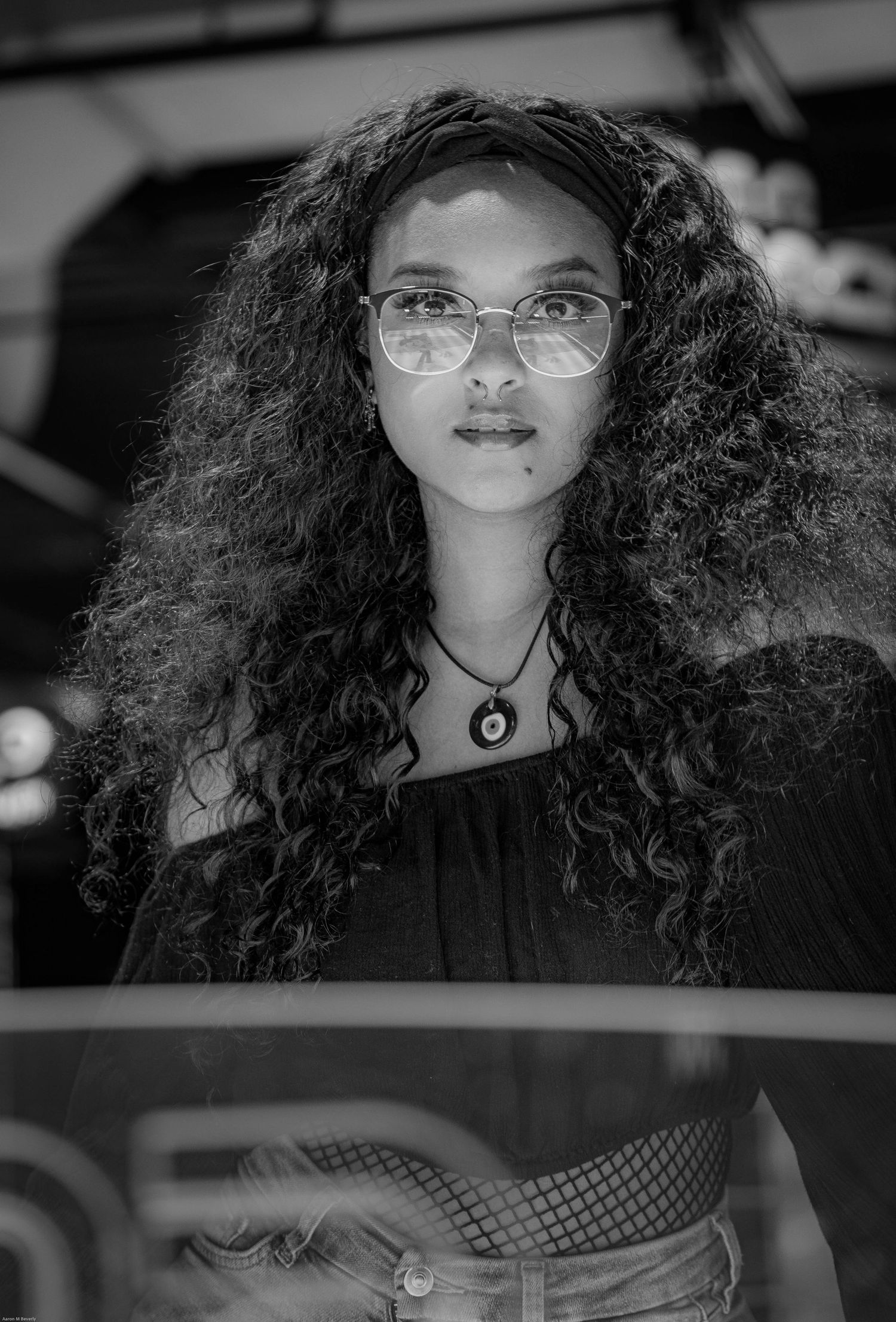 Black and white portrait featuring curly hair and glasses.