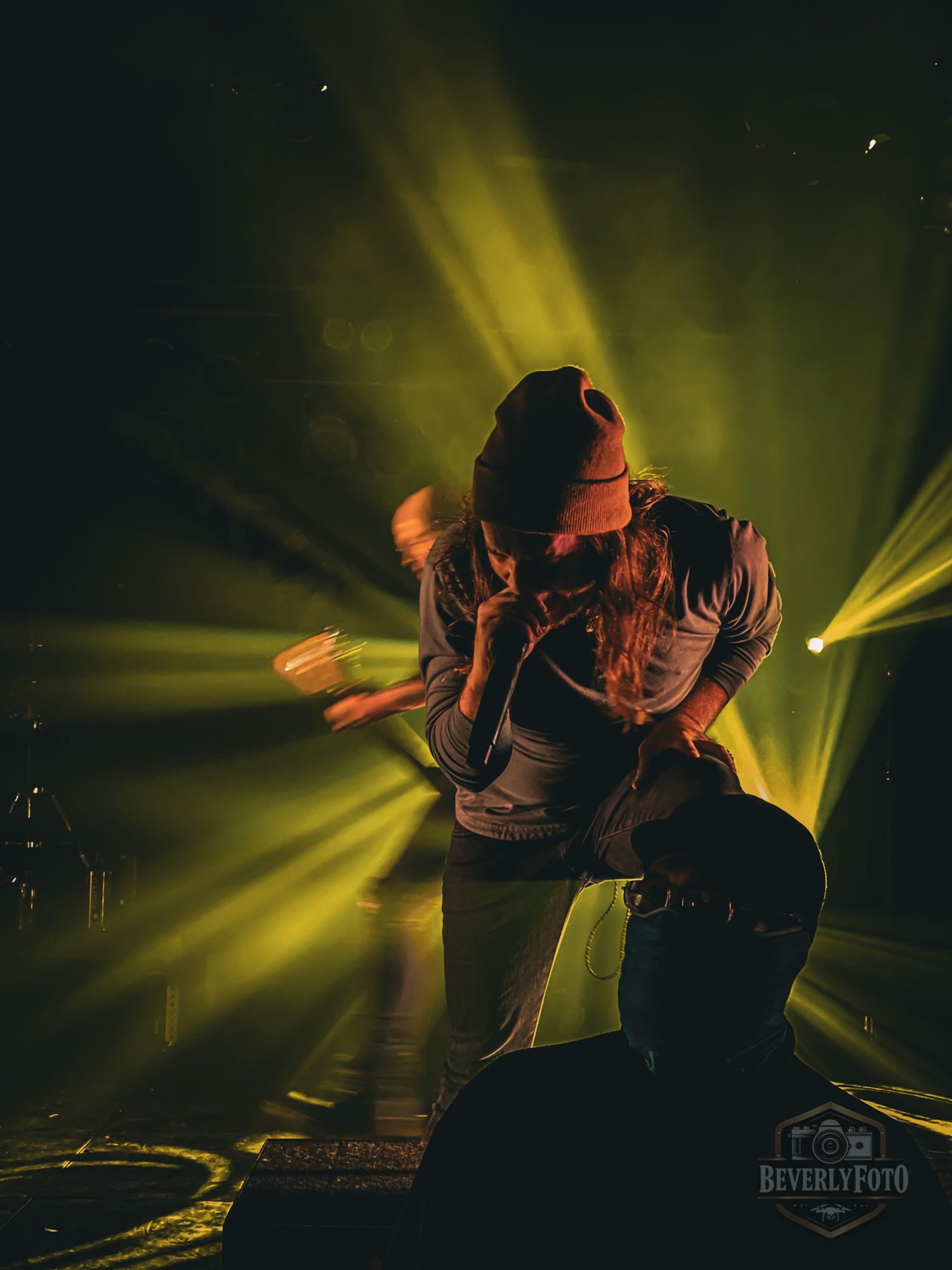 DJ performs on stage with dramatic yellow lighting effects creating a dynamic nightclub atmosphere.