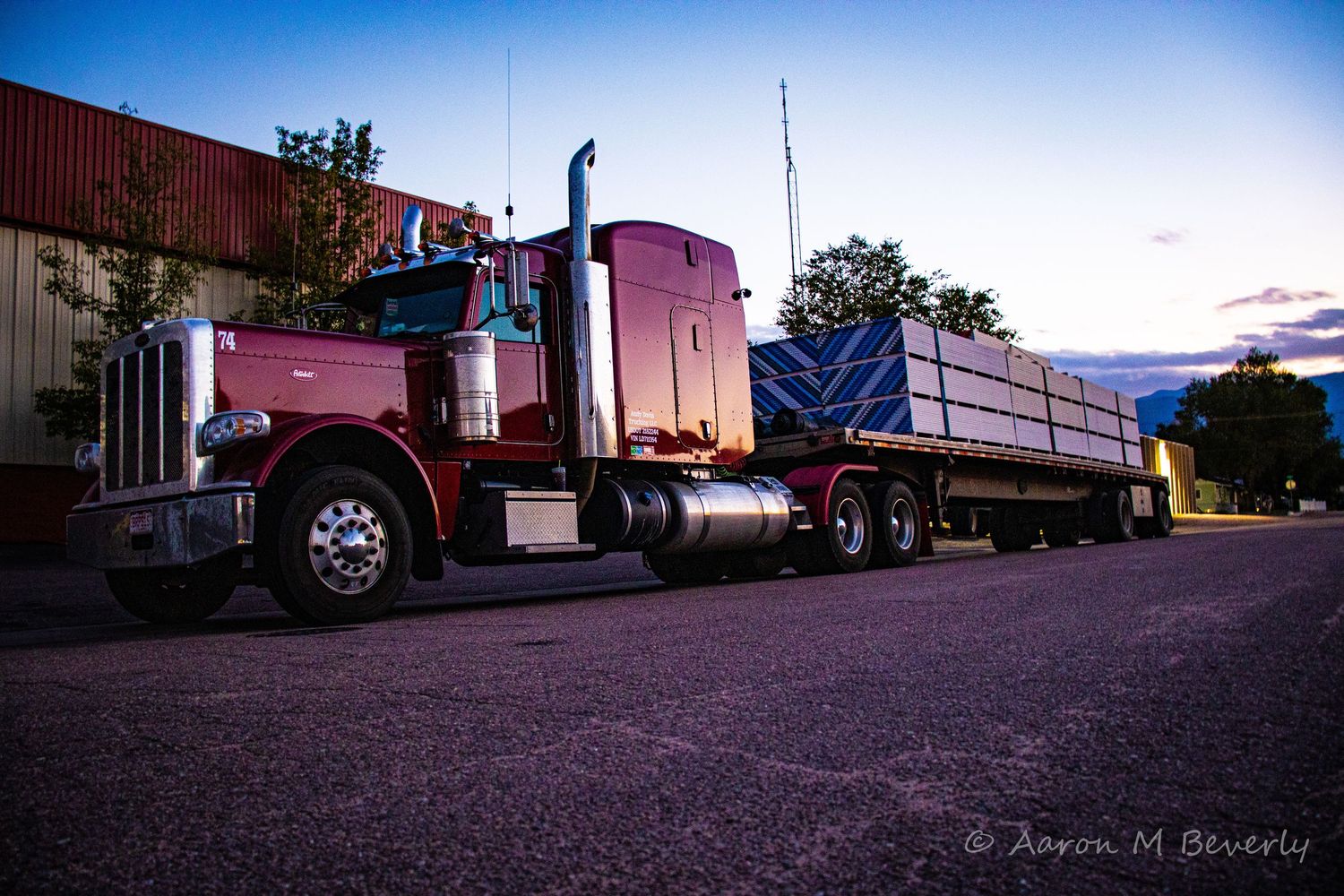 Classic Peterbilt semi truck with loaded trailer photographed at twilight.