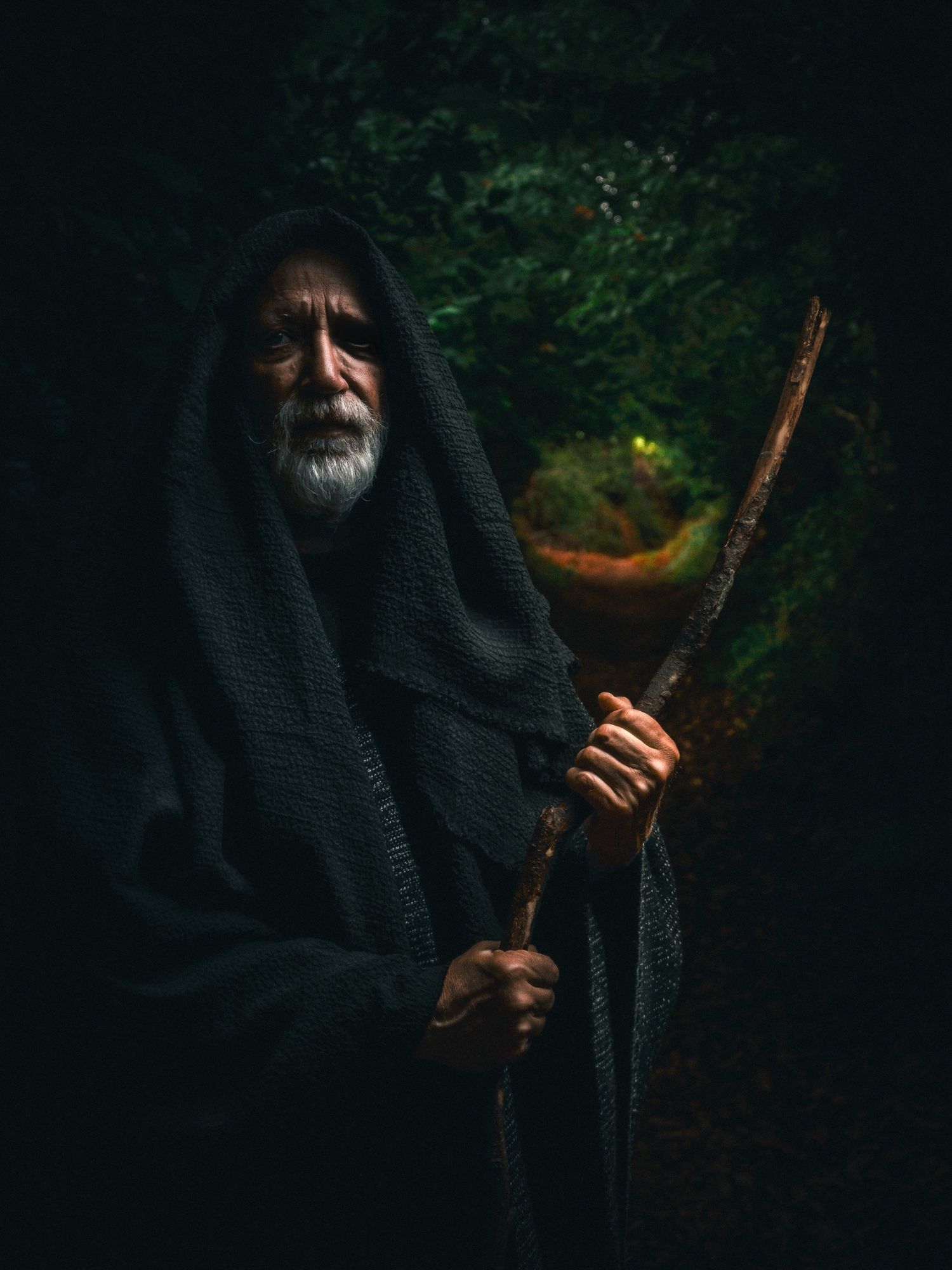 Photo d'un homme vêtu d'un long manteau noir et tenant un bâton inspiré de la légende du dieu Odin dans la mythologie nordique et scandinave