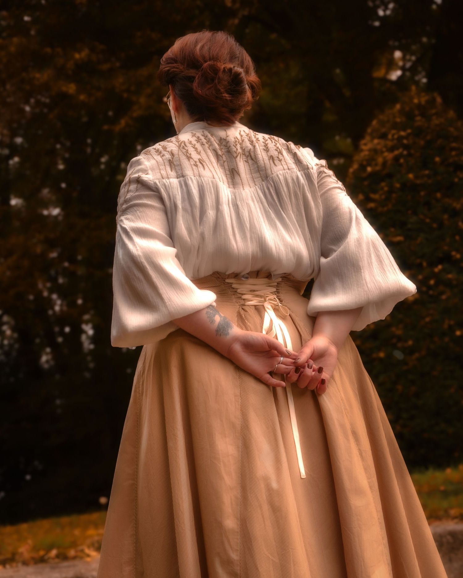 Photo d'une femme de dos habillée en costume d'époque, historique, comme au début du 20e siècle.