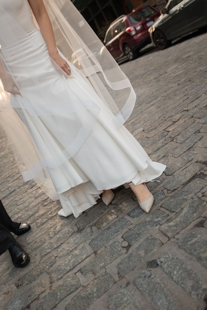 bride showing shoes on cobblestone street