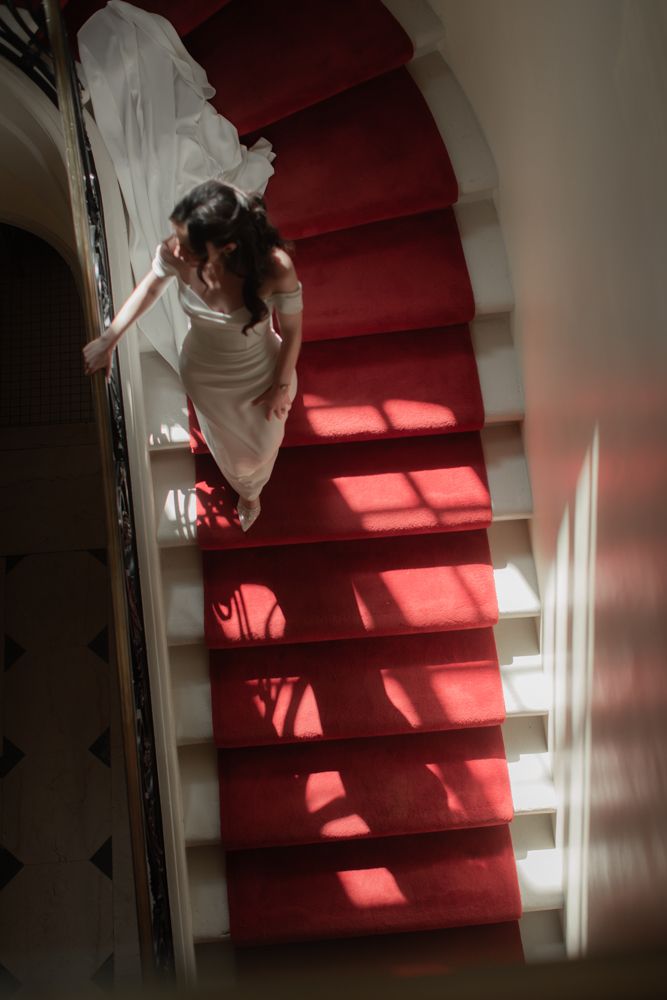 bride walking down red carpeted stairwell