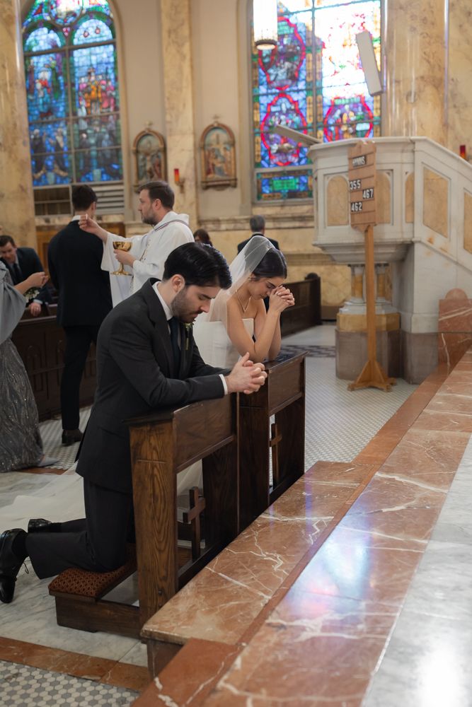 bride and groom praying at church