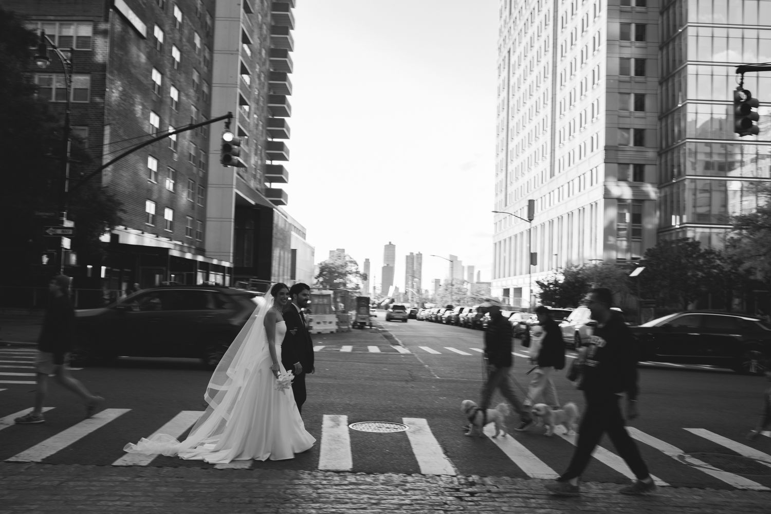 black and white photo of bride and groom crossing the street in NYC
