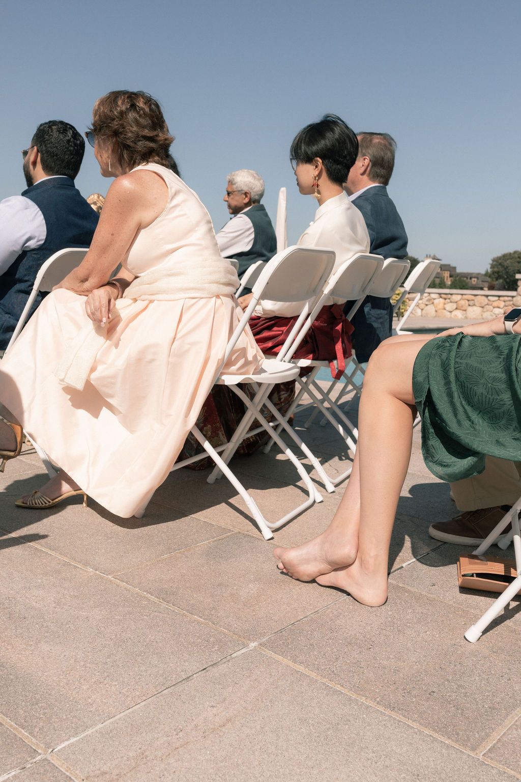 group watching a wedding ceremony in folding chairs