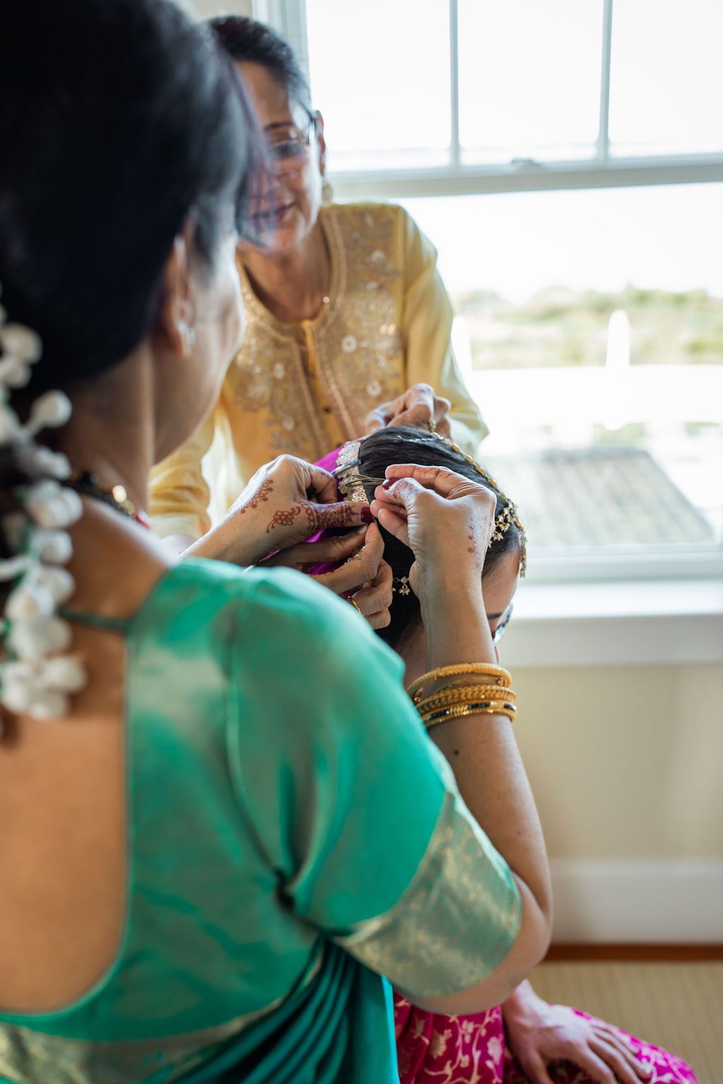 woman getting ready for indian wedding ceremony by adjusting hair