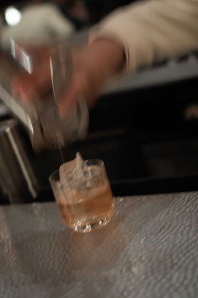 artistic photo of bartender pouring a drink