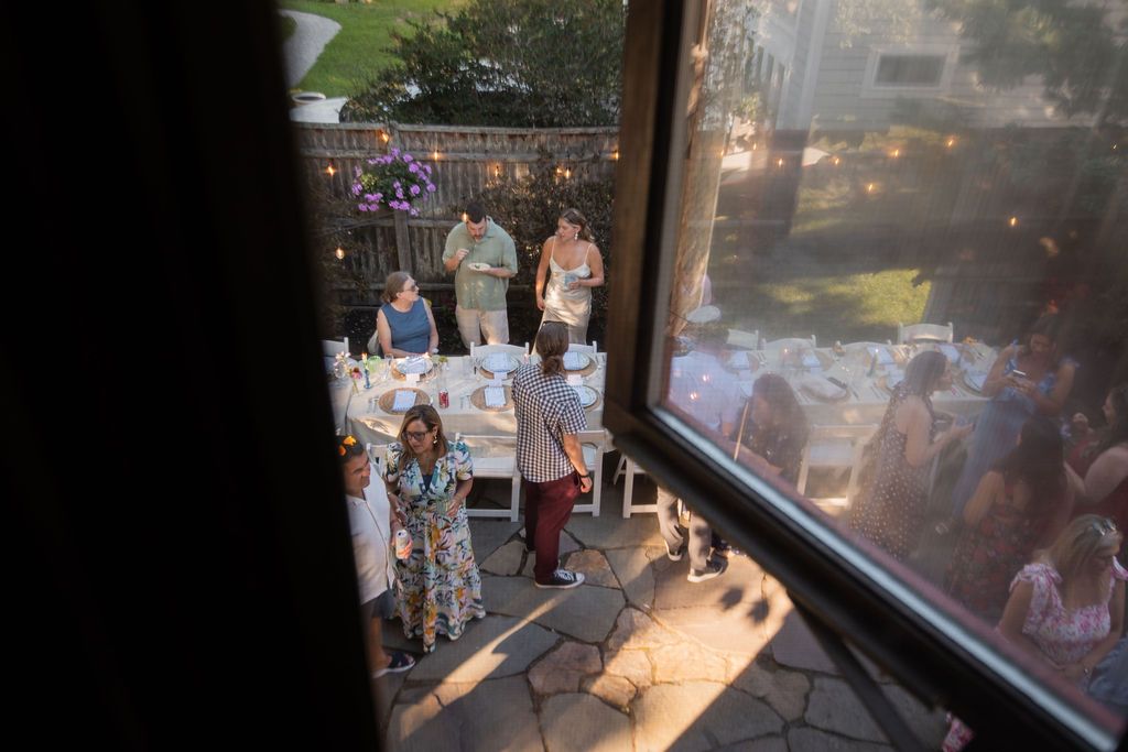 backyard wedding reception shot through the window of second floor house