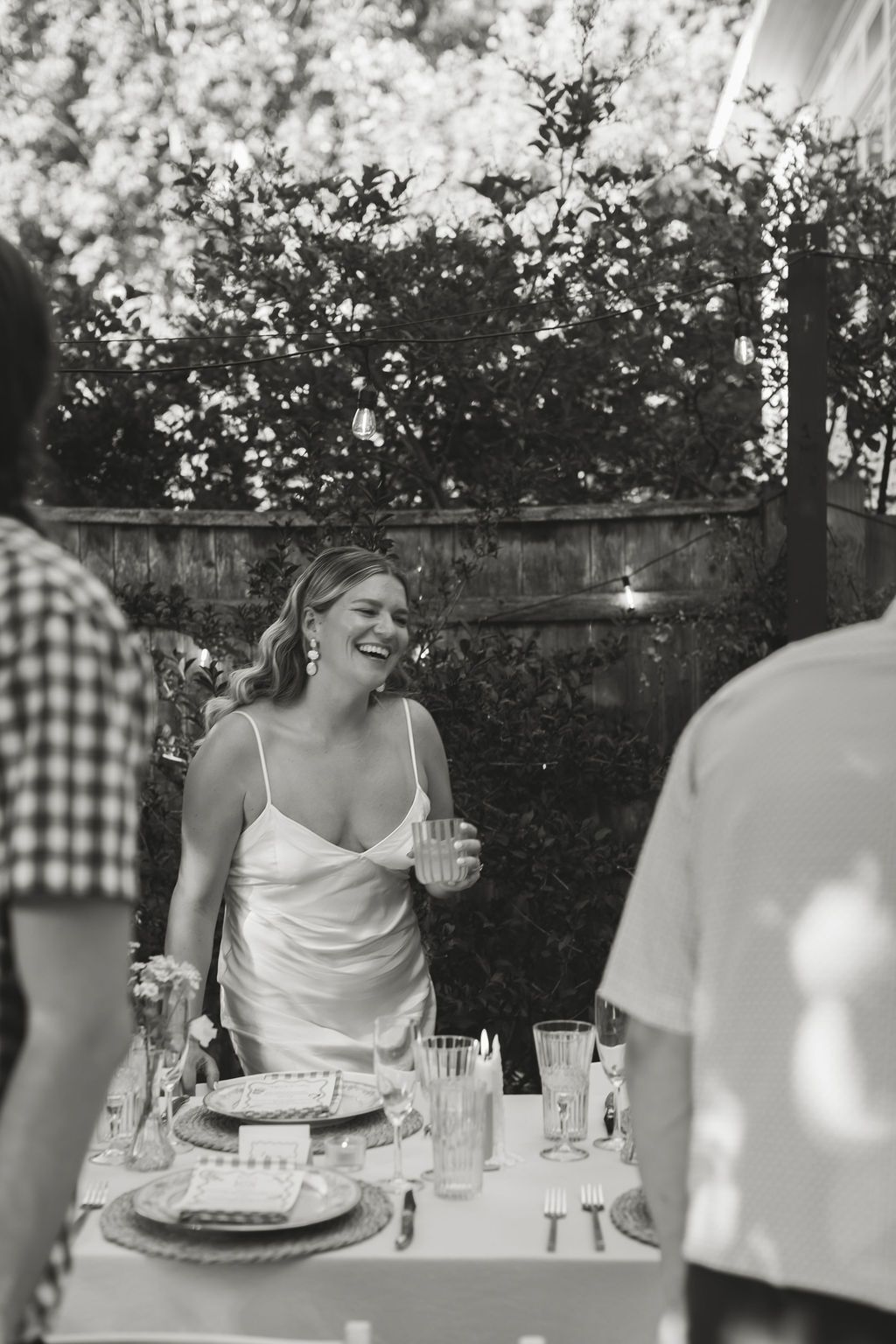 bride laughs at backyard wedding reception