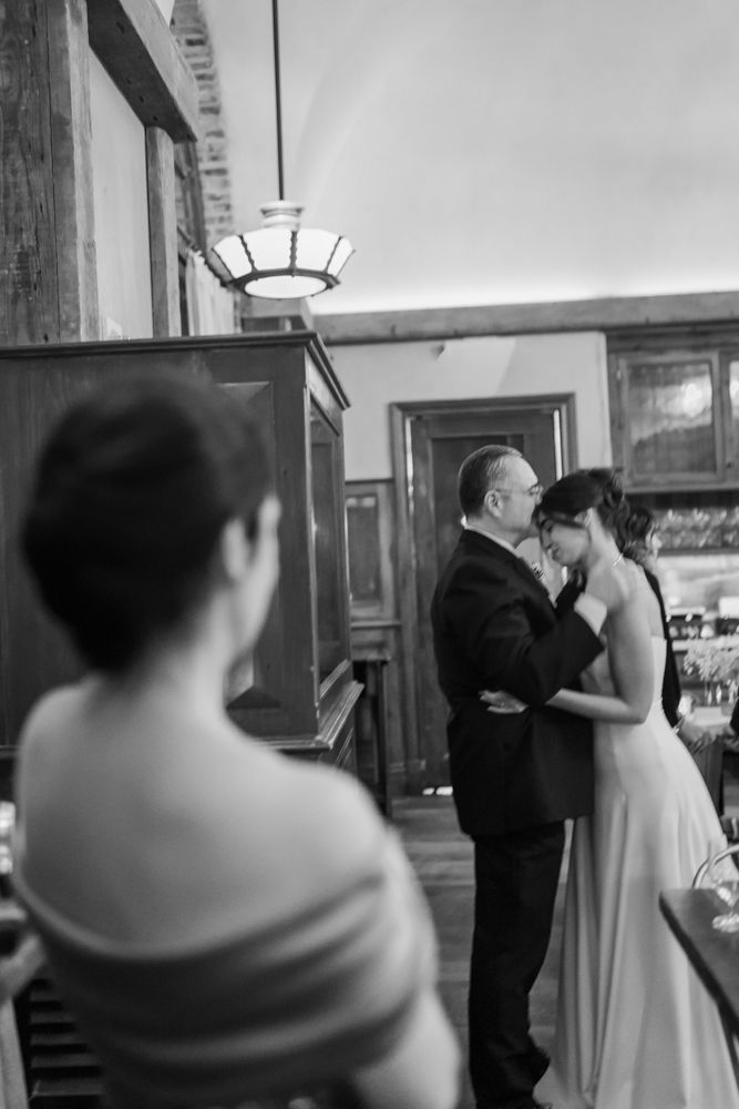 mother watching father of the bride give kiss on the forehead