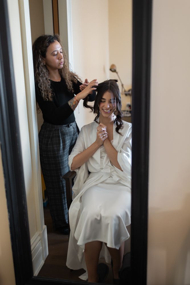 bride getting hair done in hotel room