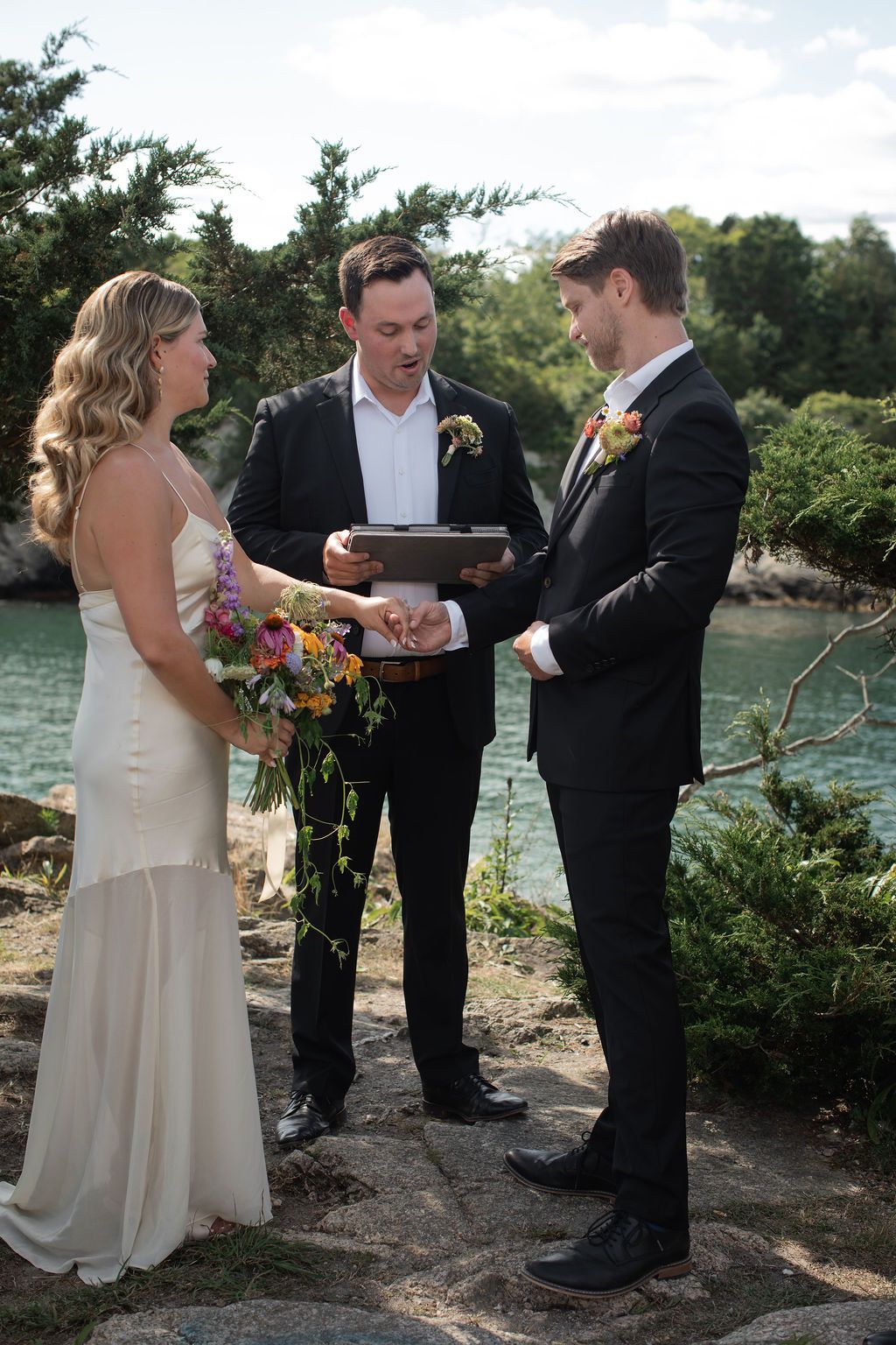 bride and groom exchange vows with officiant on sunny day