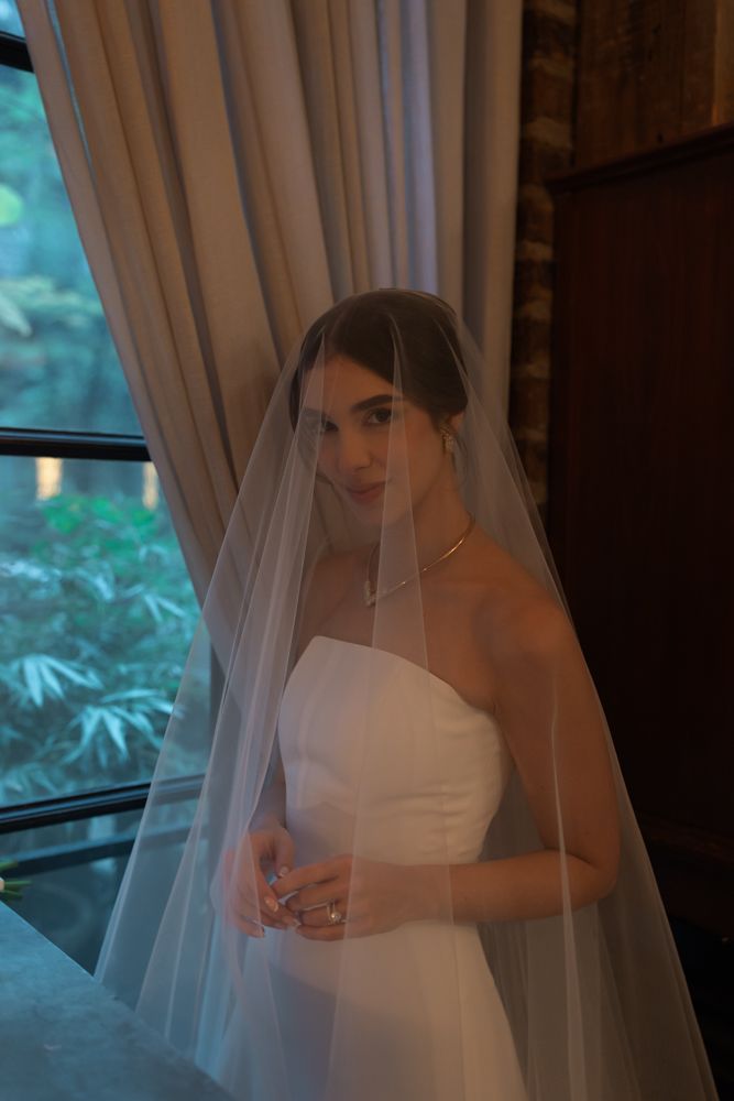 bride in wedding dress near window