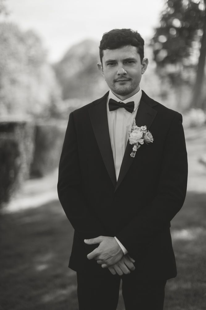 black and white photo of groom posing