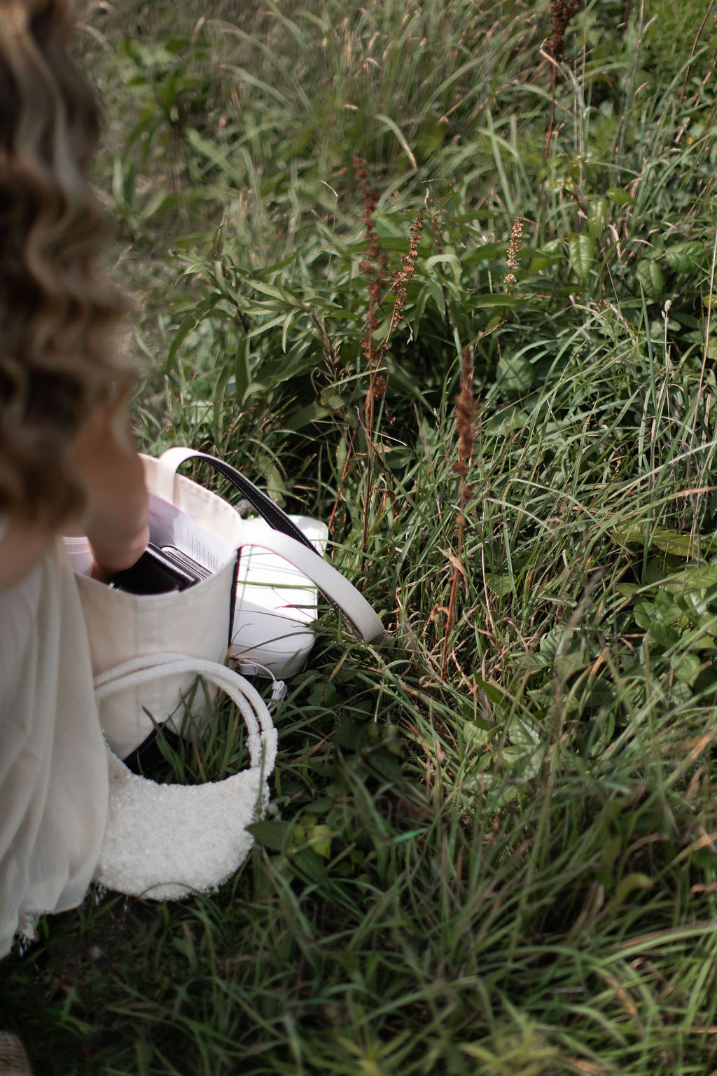 bride getting something from her purse on the ground