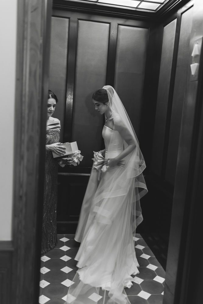 candid black and white photo of bride in the elevator