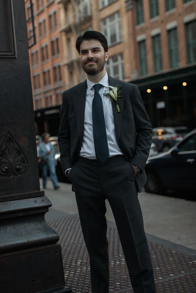 groom posing for photo with hands in pockets