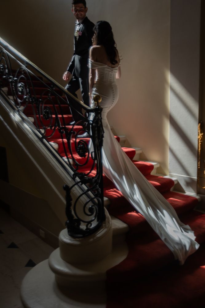 bride and groom walking up a winding staircase