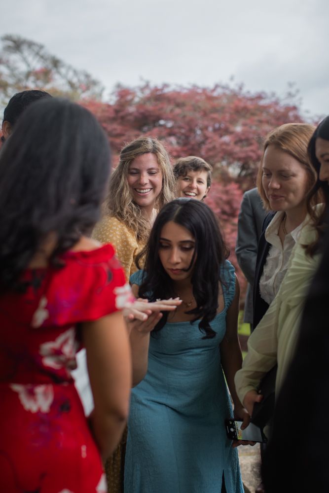 guests looking at wedding ring on brides hand